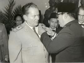 Presiden Yugoslavia Josip Broz Tito (kiri) menerima pin dari Presiden Indonesia, Sukarno (kanan).